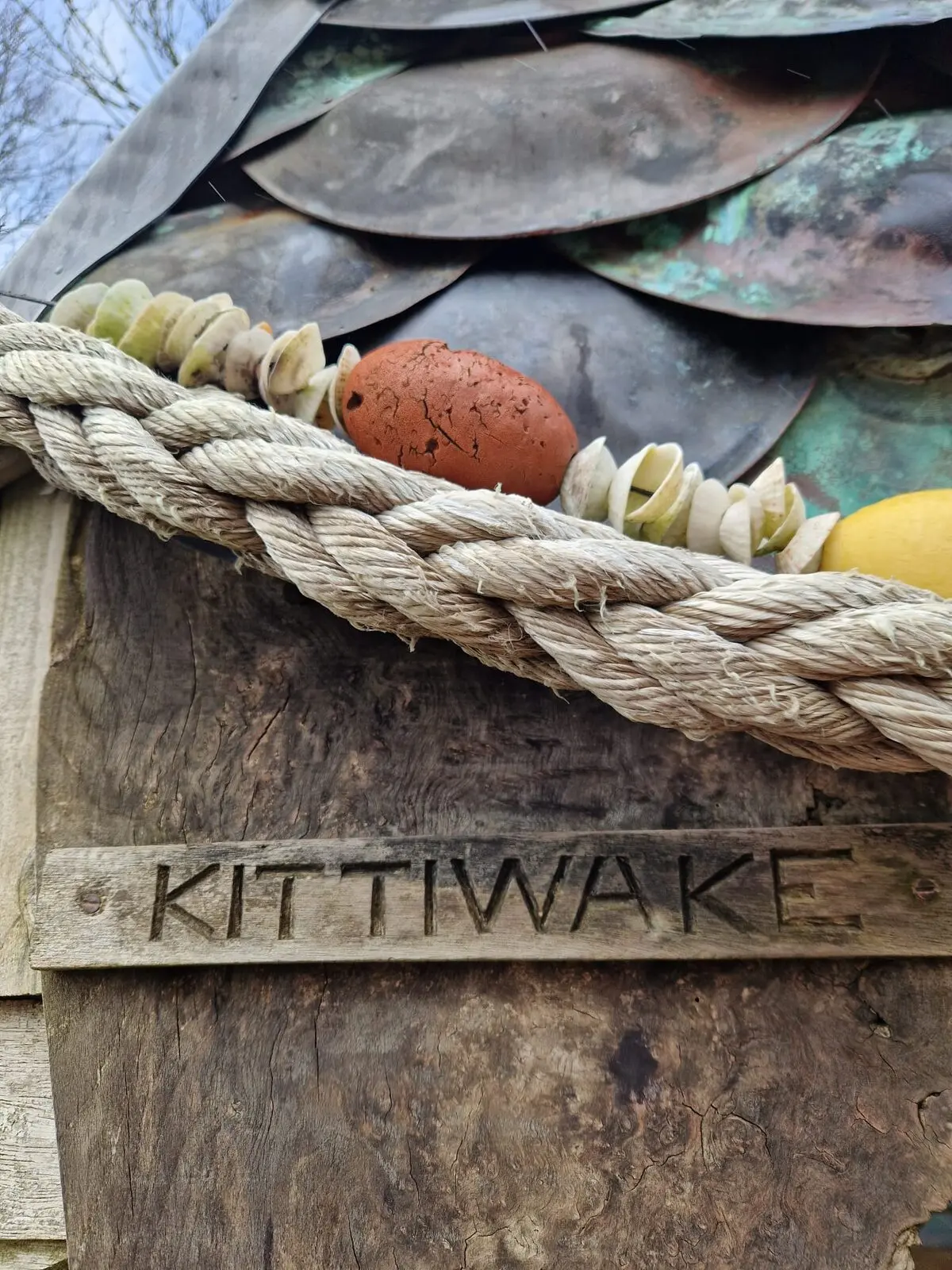 KITTIWAKE carved into the wooden lintel with braided rope and copper roof scales above